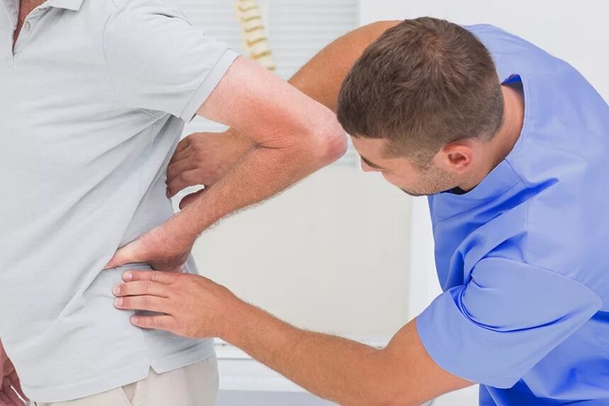 Een patiënt met lage rugpijn bij een diagnostisch onderzoek door een arts